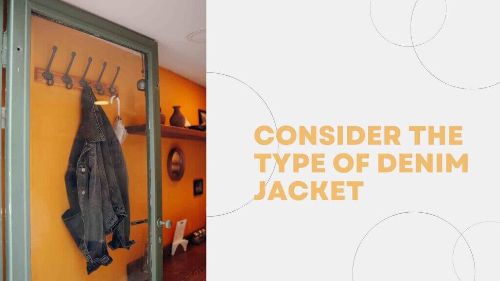 a black denim jacket is hanging in a wall hanger against an orange wall.