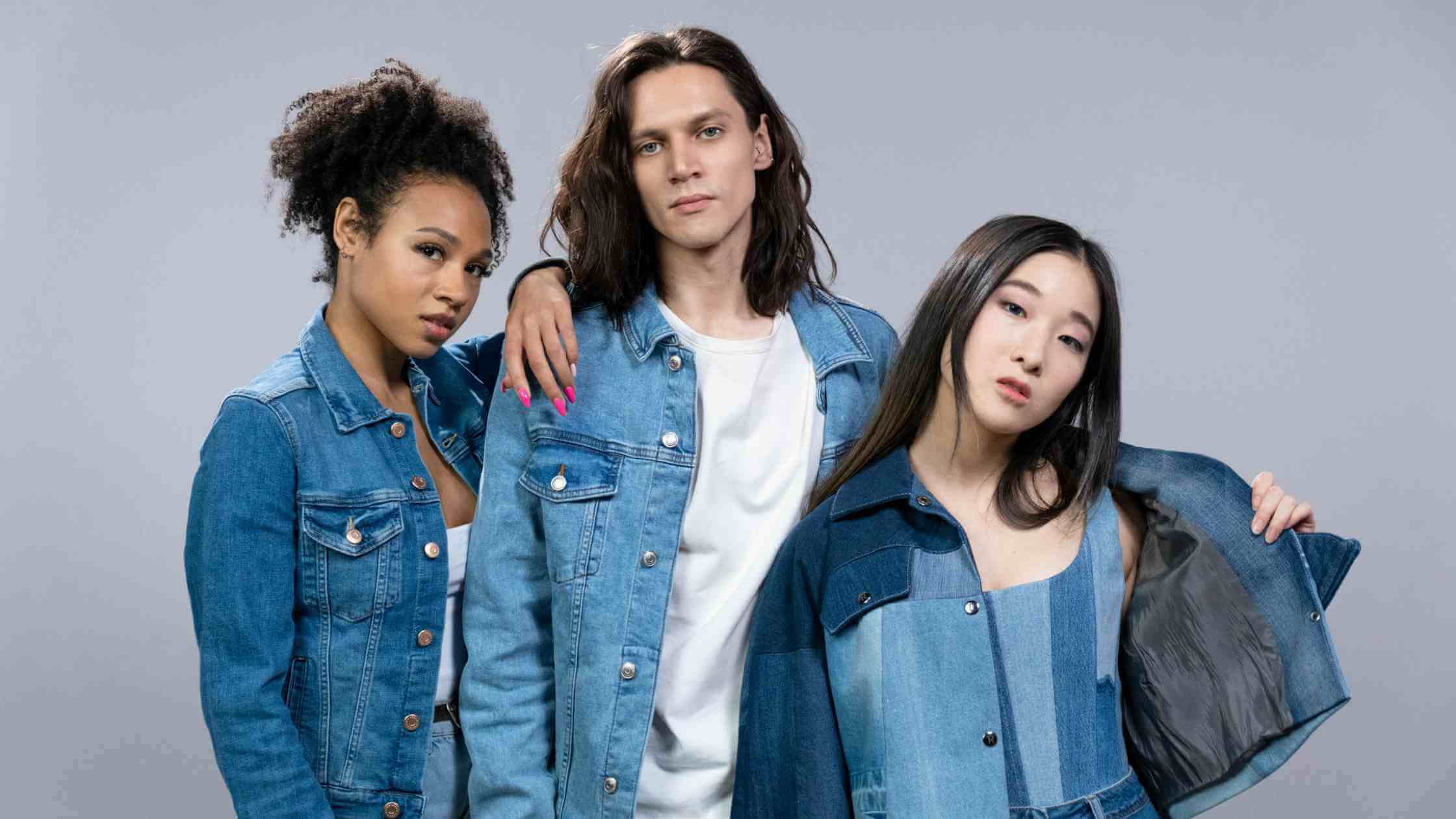 in a group picture of two women and man; they are wearing different types of denim jacket